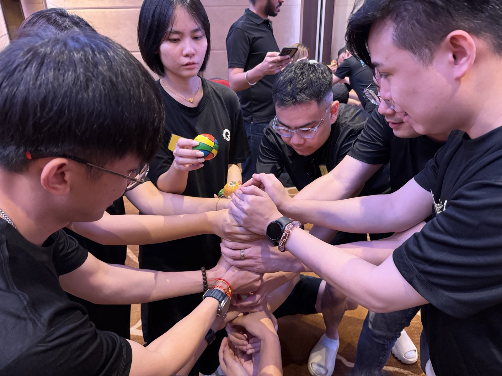 A team huddled in a circle with hands stacked together during an activity