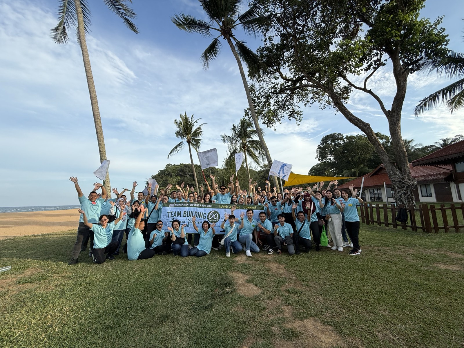 A large group photo on the beach at a company retreat